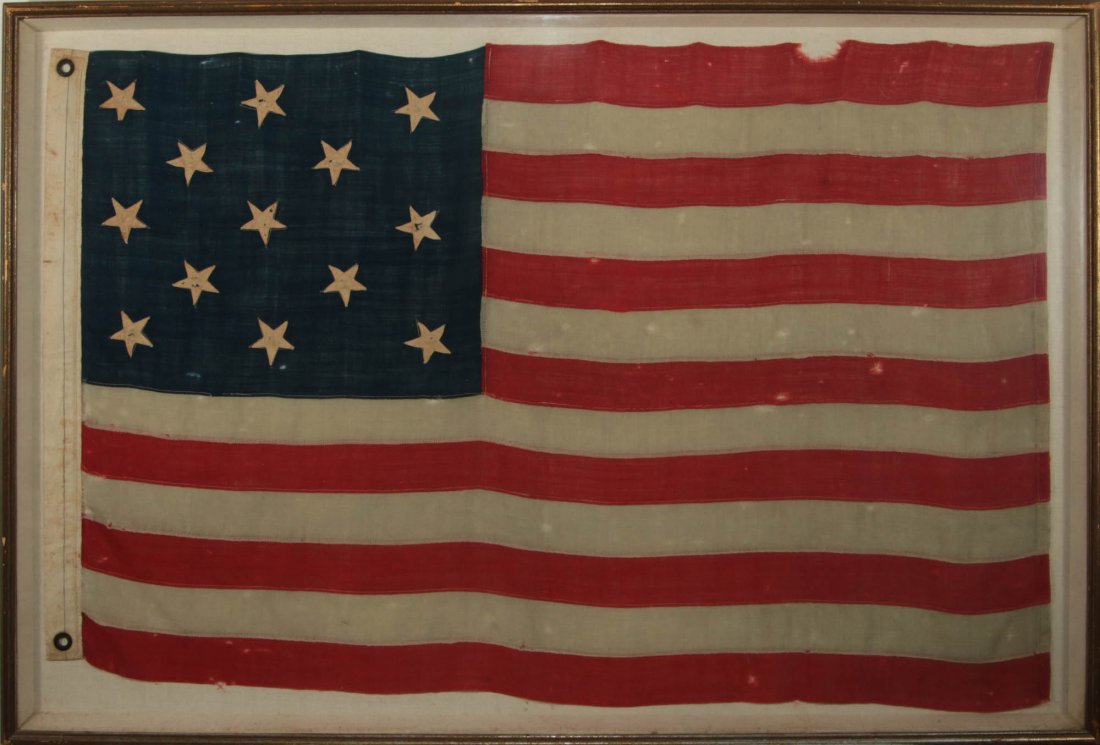 A LATE 19TH CENTURY AMERICAN THIRTEEN STAR FLAG: A hand-sewn bunting ensign flag of the type that was used in both official capacity and by private citizens. The Navy used similar flags on small craft in the 1870s and American citizens commemorated 