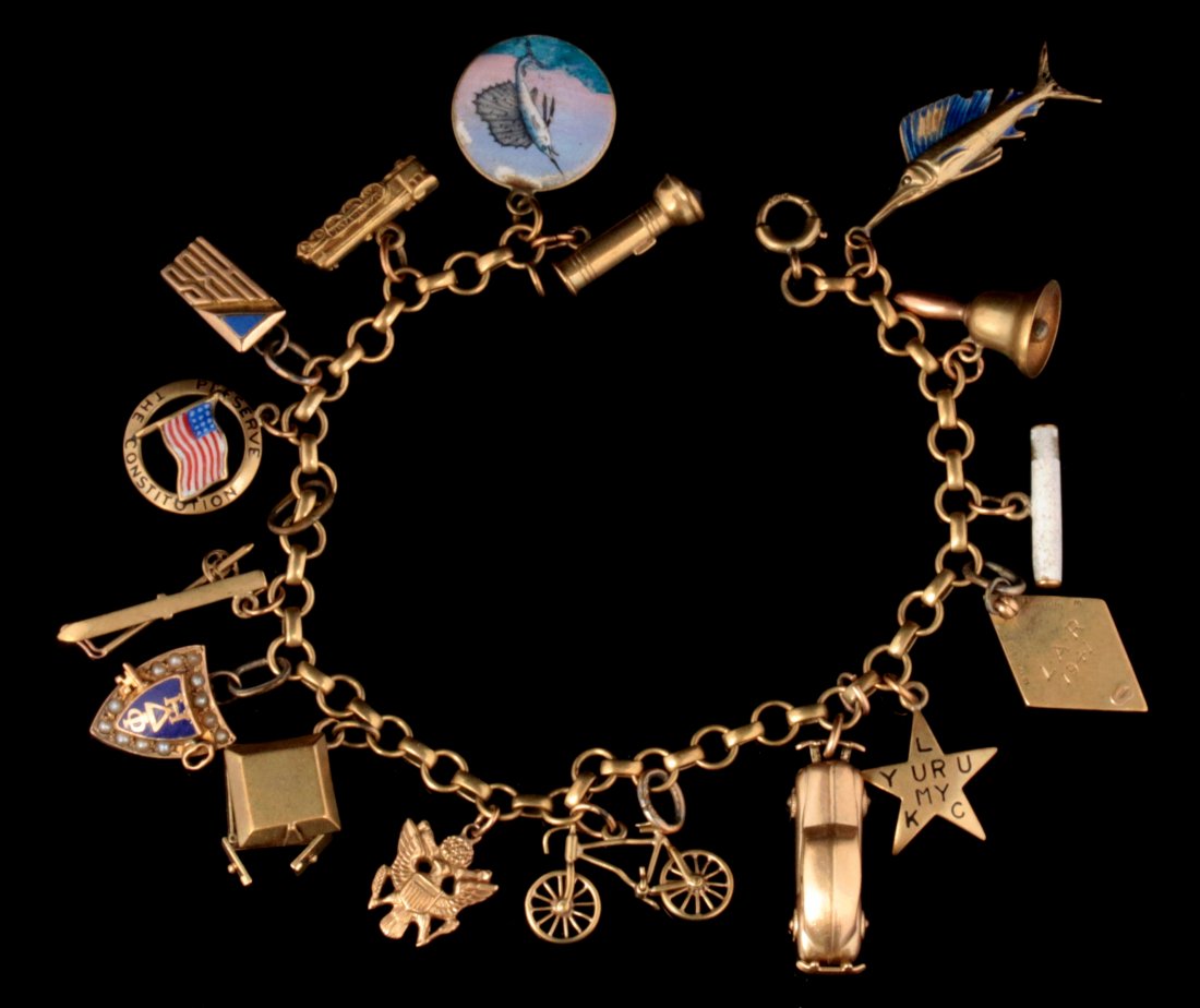 A 14K GOLD CHARM BRACELET WITH SIXTEEN CHARMS: Bracelet marked for 14k gold on the clasp, sixteen charms marked for or test for 14k gold, wrist size 6.75 inches, weighs 26.8 grams. We ship in-house for all items with the exception of very large an