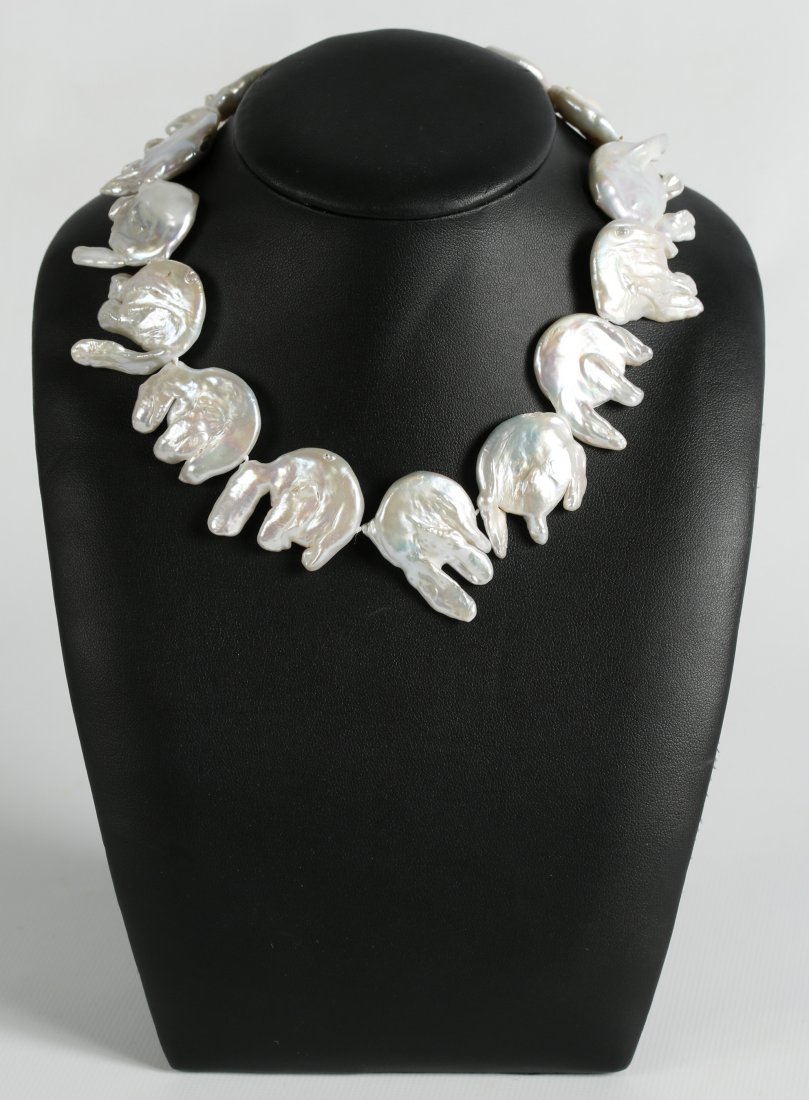 AN UNUSUAL KESHI PEARL CHOKER: Fourteen irregular shaped keshi pearls that average approximately 30 mm, strung with a 14 kt gold clasp. Measures 15 inches. We ship in-house for all items with the exception of very large and or very