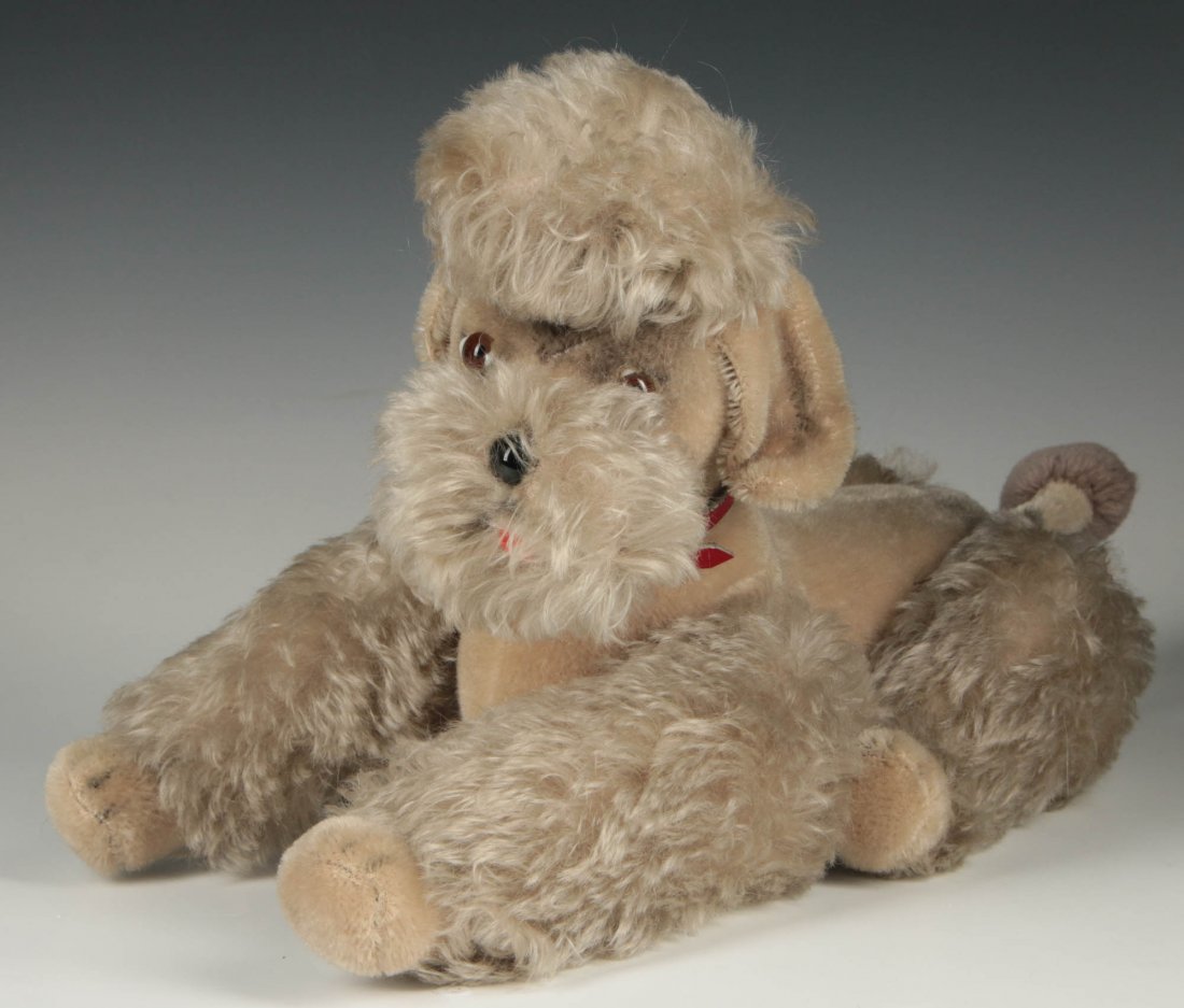 A 16-INCH BLONDE PLUSH MOHAIR POODLE WITH STEIFF BUTTON: A stuffed poodle 7 x 16 x 8 inches, original Steiff collar, glass eyes and nose, Steiff button in the ear. We ship in-house for all items with the exception of very large and or very fragile pieces an