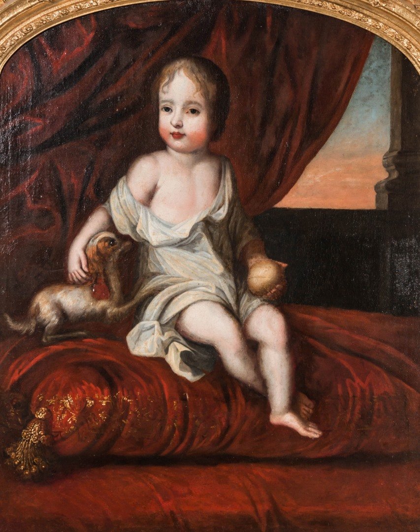 AN EARLY 19TH CENTURY PORTRAIT OF CHILD WITH DOG: A child seated on red velvet cushion embellished in gold thread, a red velvet drape and column in the background, a small dog to his right and a golden orb? in his left hand. Unsigned, the remains of
