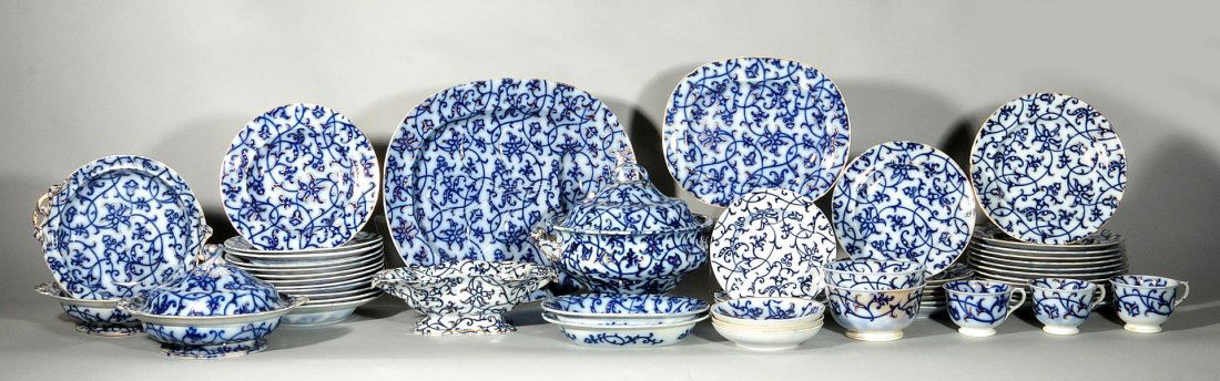 WILLIAM RIDGEWAY ROYAL LILY FLOW BLUE CHINA: Large set of W.B. & Co. William Ridgeway 'Royal Lily' pattern china, circa 1834-1854. All flow blue style with painted gold highlights. Includes twelve 10.25 inch dinner plates; two 3 x 11.5 inch foot
