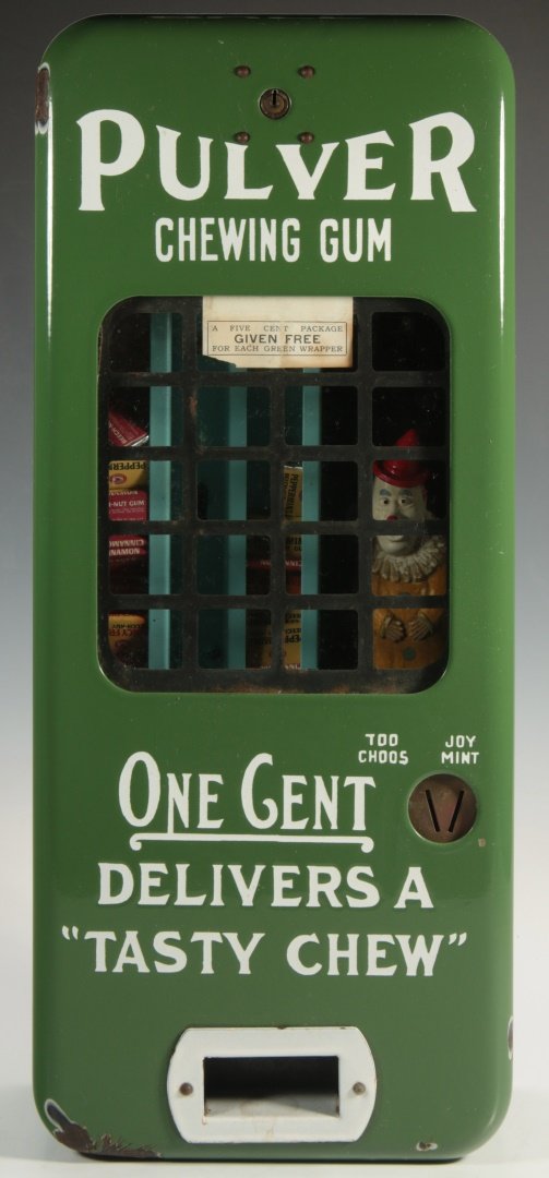 PULVER 1 CENT GUM MACHINE WITH CLOWN IN GREEN CASE: A coin-operated wall mount vending machine by Pulver Company Inc. "Pulver Chewing Gum/One Cent Delivers A Tasty Chew" in white typography on a green enameled ground, fitted opening with metal grill, o