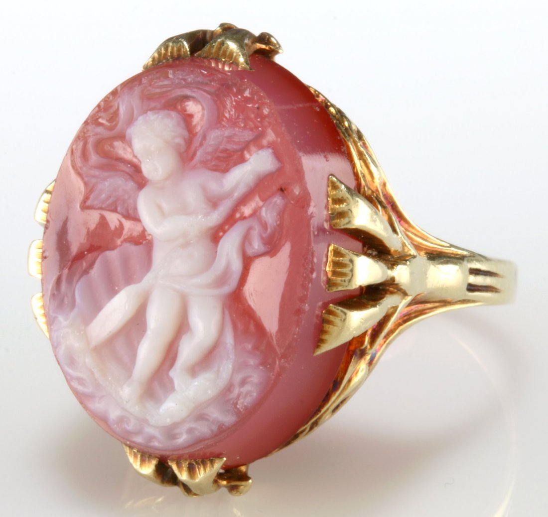 A 14K GOLD RING WITH A CARVED CARNELIAN CAMEO: A carved cameo of Cupid set in a 14k gold setting, unmarked, acid test for 14k gold, the carved stone cameo is signed back side and measures 18 x 14.5 mm, ring size 6.5, weight 6.8 grams. We ship in-h