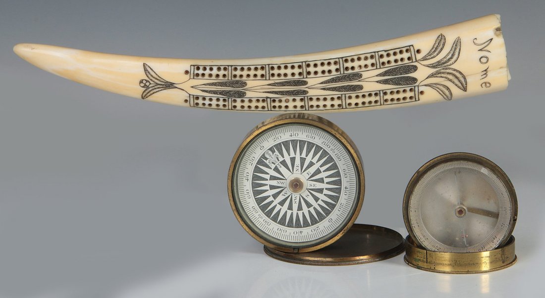 A NORTHWEST COAST WALRUS TUSK CRIBBAGE BOARD: A 9.5 inch cribbage board together with two smaller functional compasses, grouped together to wrap up an estate parcel. We ship in-house for all items with the exception of very large and or very frag