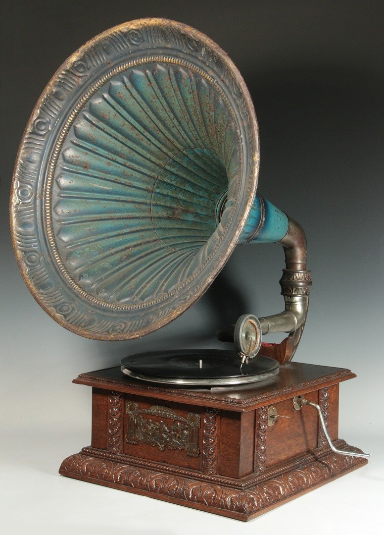A C. 1900 OAK CASE PHONOGRAPH WITH OUTSIDE HORN: An oak case with original painted metal lobed morning glory horn. Marked Monophone-Extra on the reproducer and attributed to the Sankodo Menophone Co. We ship in-house for all items with the exception