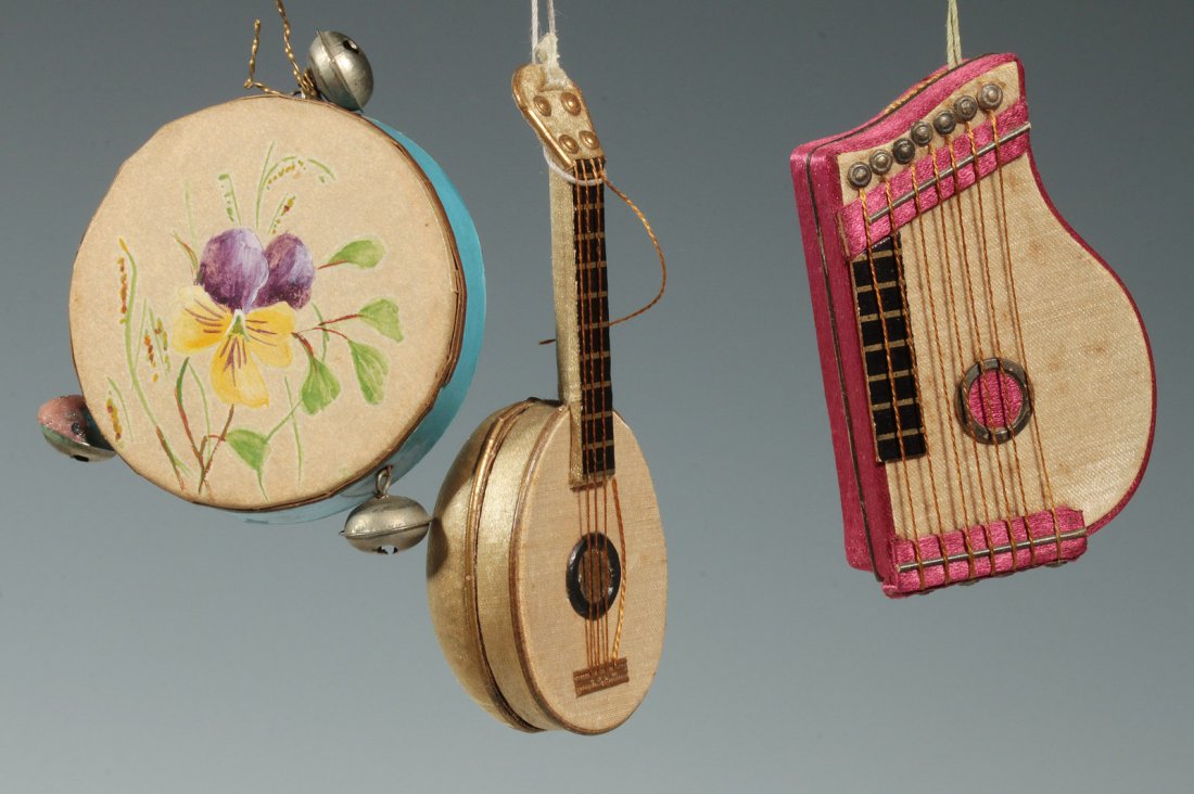 THREE CIRCA 1900 GERMAN CANDY CONTAINERS: Three antique paper candy containers in the form of musical instruments: a mandolin, tambourine and a lap harp. The tambourine has a hand-painted pansy on the top. Measure 2, 2.25 and 3 inches each.