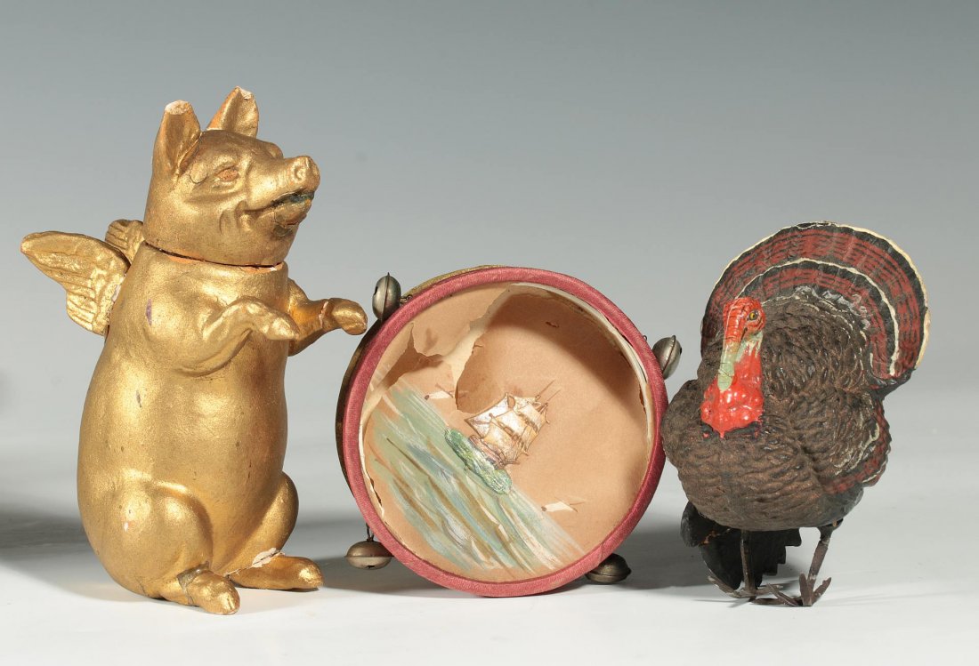 GERMAN CANDY CONTAINER AND PAPER HOLIDAY ORNAMENTS: Pig candy container measures 4.5 inches, chips and breaks as shown, possibly repainted. Turkey paper mache ornament measures 3.5 inches, chips and repairs as shown. And a Dresden paper tambourine thre