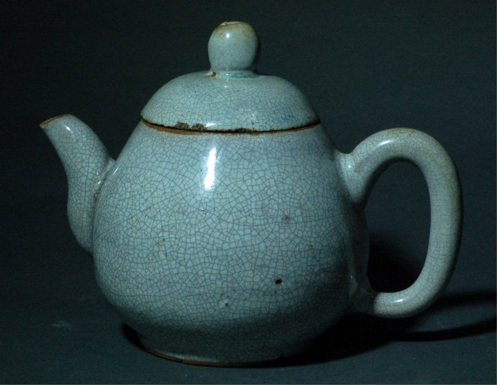 Chinese Zisha Porcelain Teapot: A Chinese ZiSha porcelain teapot, cover overall white glaze suffused with dark black crackle. Late Qing Dynasty Size: 6’’ H, 8’’ W