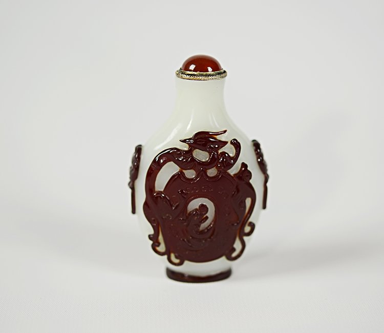 19th Century Chinese Peking Glass Snuff Bottle: 19th Century Peking Glass Snuff Bottle, the opaque white body with ruby red overlay decoration of phoenix and dragon on the front and reverse, the sides with applied mask and ring handles; Appx. 1 1/2