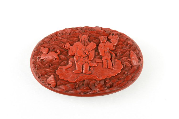 18th Century Chinese Cinnabar Lacquer Box: 18th Century Chinese Cinnabar Lacquer Box, of oval form, the top and base each carved in high relief with a Buddha and companion on a leaf boat floating atop cresting waves alongside various animals i