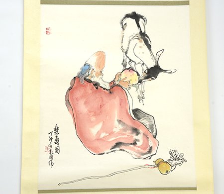 Chinese Painting of Shou Lao, Mao Guolun (b. 1944): Chinese Painting of Shou Lao, by Mao Guolun (b. 1944), the seated God of Longevity feeding a peach to a spotted deer with a staff and peaches at his side, with inscription to the lower left, painting 