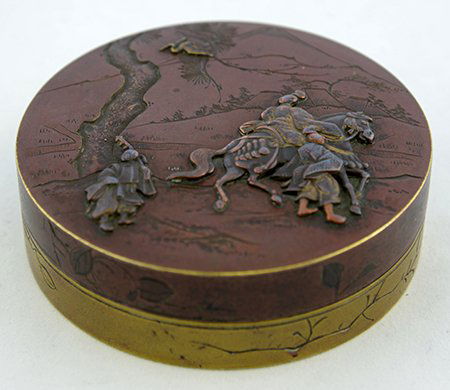 A Japanese Export Bronze Jewelry Box: A Japanese Export Bronze Jewelry Box, sold by Schumann Sons, New York, the box decorated in takazogan, the lacquered top with three men, one mounted, below a tree and crane in a mountainous landscape,
