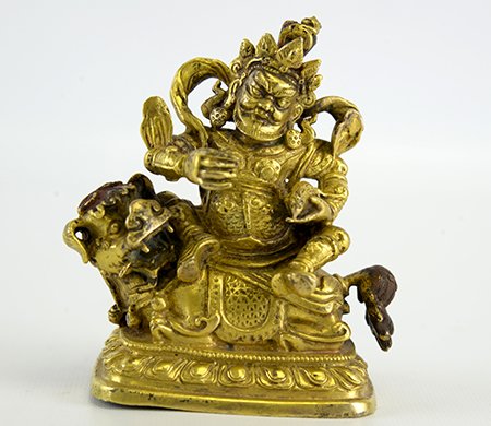 Sino-Tibetan Gilt Bronze Figure of Vaishravana: 19th Century Sino-Tibetan Gilt Bronze Figure of Vaishravana, the Buddha seated on a lion over a lotus base, his right hand in vitarkamudra and his left holding a mongoose, wearing elaborate armor and 
