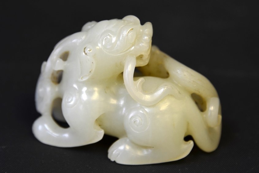 A Chinese White Jade Model of Foo Dogs: A Chinese White Jade Model of Foo Dogs, carved with a large and small foo dog sharing a lingzhi sprig, appx. 2 1/4 in. W.