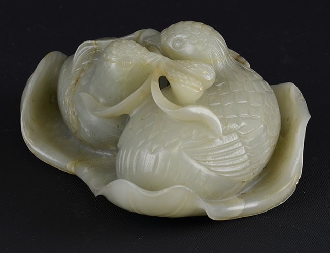 A Chinese Jade Model of Quails: A Chinese Jade Model of Quails, likely Qing Dynasty, carved to show a pair of quails on a lily pad, with some small chips to edge, appx. 4 3/4 in. W.