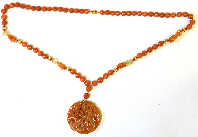 A Chinese Carnelian and 14 k Gold Necklace: A Chinese Carnelian and 14 k Gold Necklace, the necklace with carnelian and gold beads and suspending a carnelian pendant carved as a sinuous dragon, the necklace appx. 16 1/4 in. Long, the pendant ap