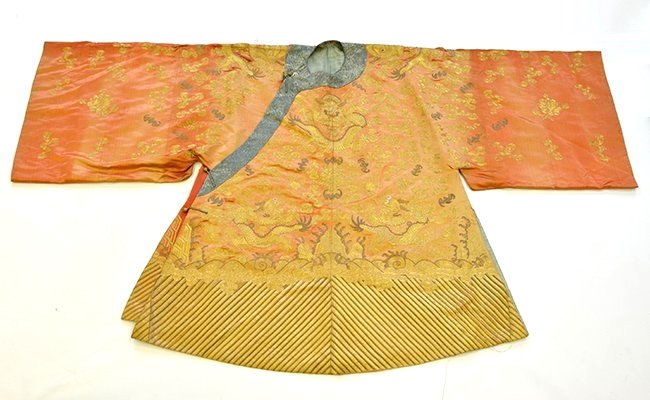 A Chinese Embroidered Dragon Robe: A Chinese Embroidered Dragon Robe, the robe couched in metallic threads to show dragons on an apricot/red silk ground, with fraying, discoloration, tears, appx. 39 1/2 in. H.