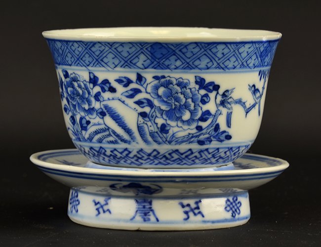 A Chinese Blue and White Cup with Stand: A Chinese Blue and White Cup with Stand, with underglaze blue diaper border encircling the slightly everted rim, the body with flowering prunus opposite inscription and above key fret border encirclin