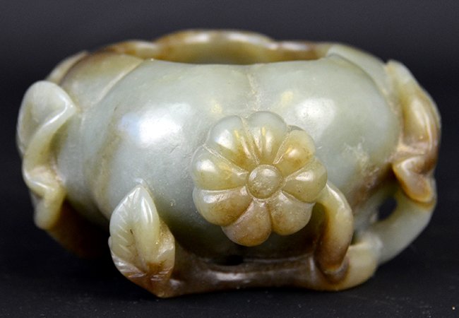A Chinese Celadon Jade Brush Washer: A Chinese Celadon Jade Brush Washer, with russet inclusions, the brush washer in the form of a gourd raised on leaf bearing branches, appx. 4 in. W, 2 in. H.