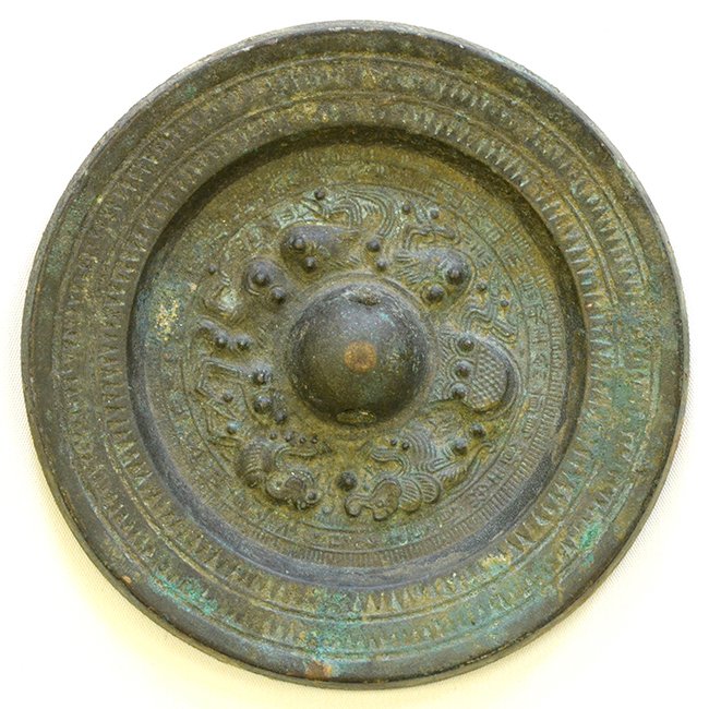 A Chinese Bronze 'Dragon' Mirror, Han Dynasty: A Chinese Bronze 'Dragon' Mirror, Han Dynasty, the circular mirror cast in high relief with a hemispherical knob encircled by confronting dragons all within concentric circles containing hatched bands