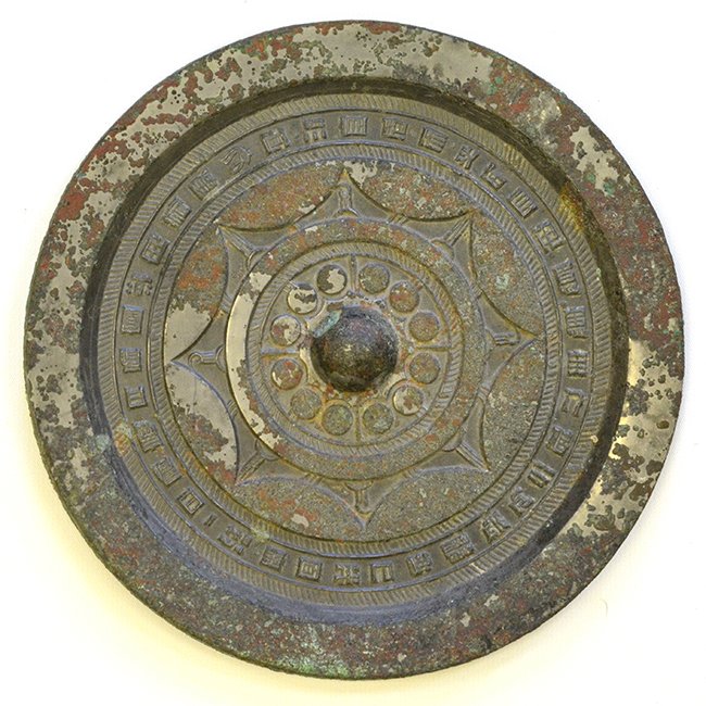 A Chinese Bronze Mirror with Inscription, Han: A Chinese Bronze Mirror with Inscription, Han Dynasty, the central boss encircled by twelve flat discs within a hatched border, all contained by a band of eight linked arcs, the outer field cast with 