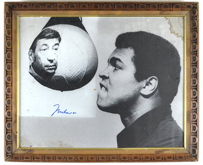 Autographed Photograph of Muhammad Ali: Autographed Photograph of Muhammad Ali, with the boxer photographed at the gym, with water damage to the upper corners, appx. 18 3/4 in. H, 22 3/4 in. W.