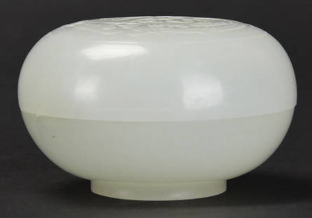 A Chinese White Jade Box: A Chinese White Jade Box, 18/19th century, with dragon and phoenix carved on lid, vein crack in side of bottom half of box, approx. 3 1/2 by 6 cm. diam, 1 1/2 by 2 1/2 in. diam.