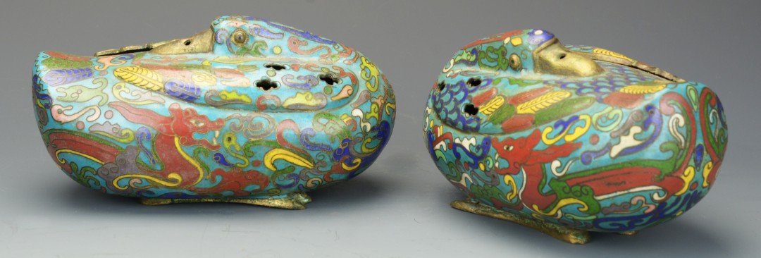 A Pair of Chinese Cloisonne Duck Censers: A Pair of Chinese Cloisonne Duck Censers, reclining blue cloisonne ducks with red, green, blue, and yellow feathers and scrollwork, pierced wings, one wing on each serving as lid, on two gilt feet, ap