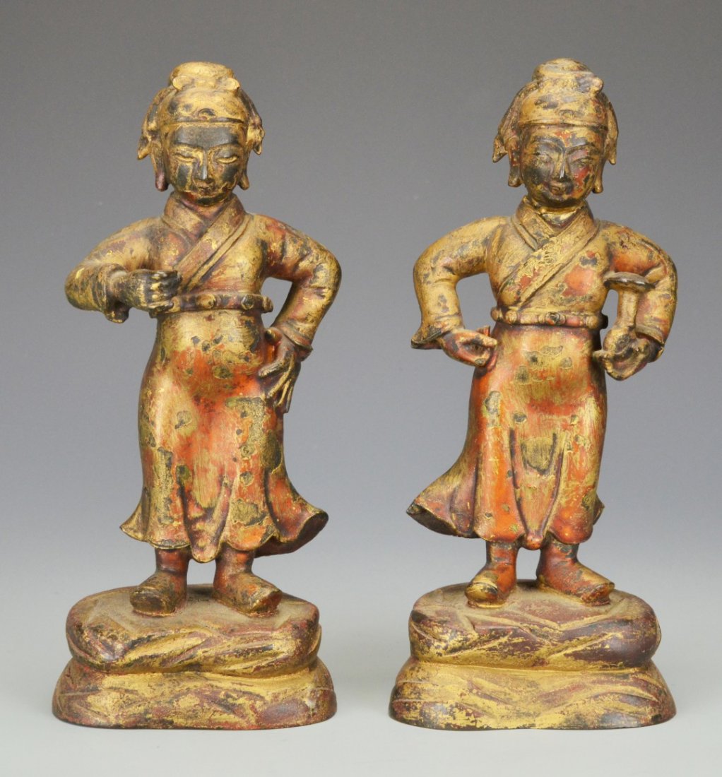 A Chinese Pair of Gilt Bronze Figures: A Chinese Pair of Gilt Bronze Figures, Qing dynasty, the figures each standing on a plinth with draping robes flowing in mirror image, one standing with hands on hips holding a lantern, the other with