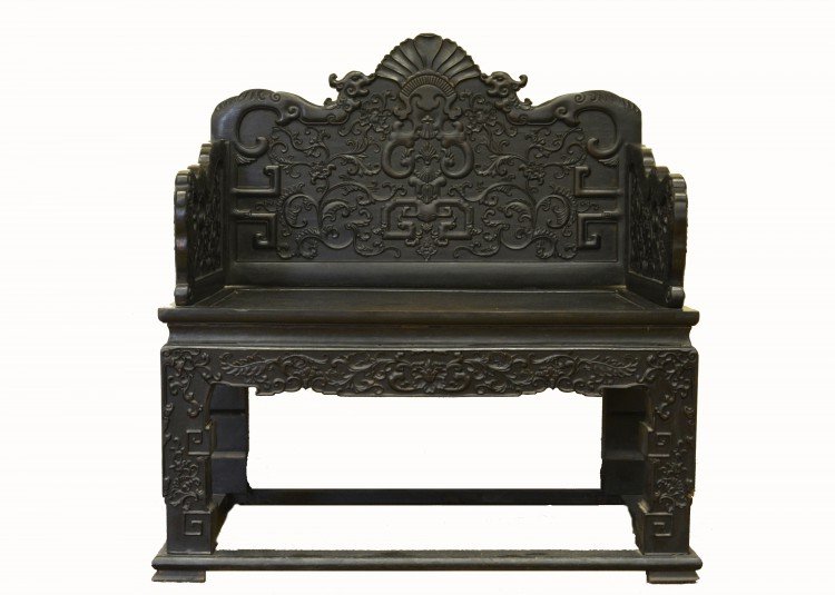 A Chinese Hardwood Throne Chair: Qing dynasty, carved back with confronting dragons along the cresting rail above a lotus bearing meander, the sides similarly decorated, with cracks, approx. 42 1/2 by 39 1/4 in., 108 by 100 cm. Prove