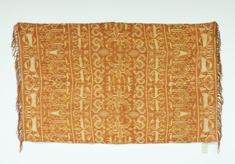 An Indonesian Ikat Blanket: An Indonesian Ikat Blanket, from Sumba, Lesser Sunda Islands, the two panel blanket made with red and ivory dyes, decorated with stylized animal, bird and human forms, approx. 247 5/8 by 144 34 cm, 97