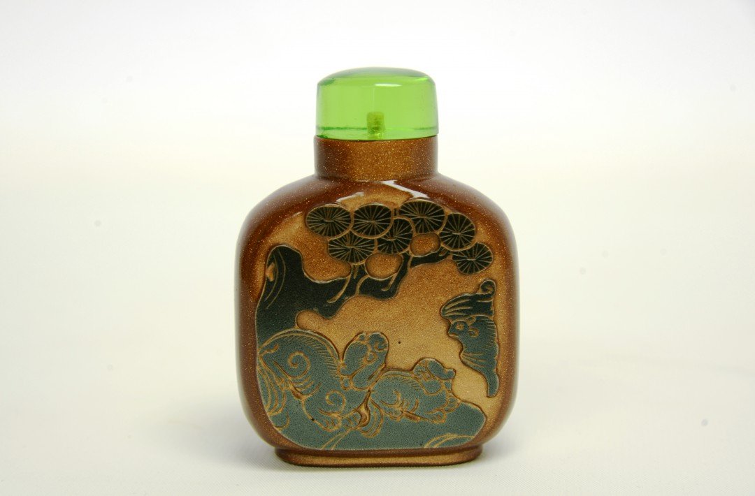 A Rare 18th Century Goldstone Aventurine-Glass Snuff: 1736-1800, Qianlong period, Qing dynasty. Attributed to the Imperial Glassworks, Beijing, the snuff bottle with a flat lip and oval foot ring in caramel brown glass suffused with shimmering crystallin