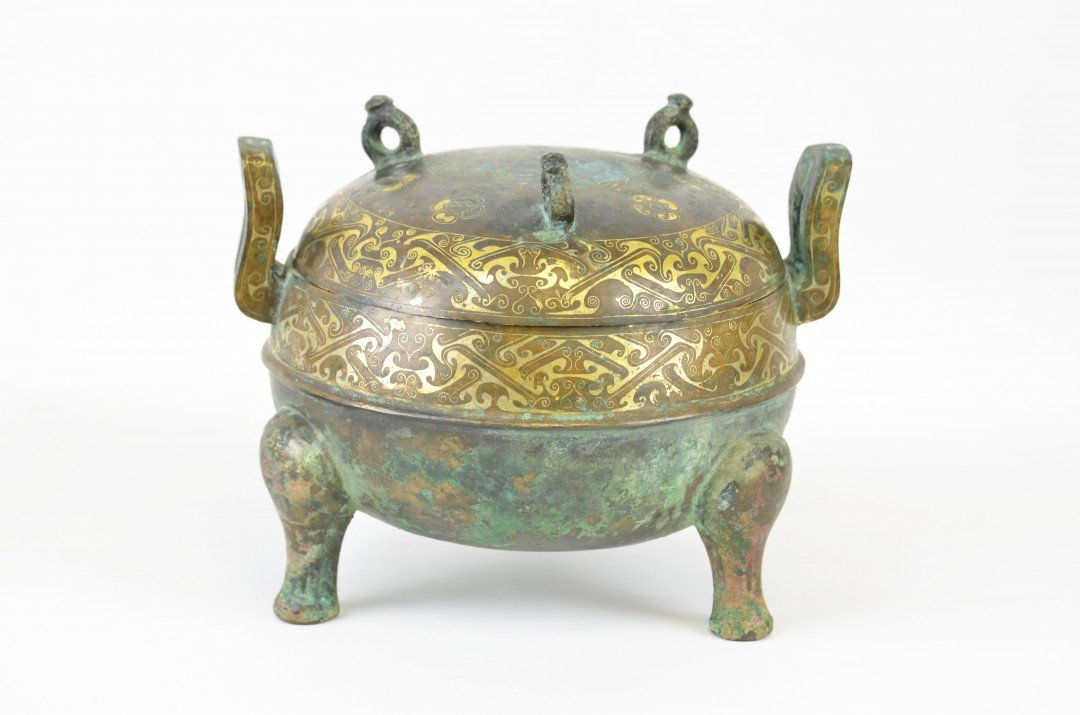 A Gilt Bronze Ritual Ding Vessel and Cover: Late Zhou Dynasty (1046-256 BC). The compressed globular body encircled by a single raised band and set at the rim with a pair of loop handles, the domed cover surmounted by three small ring handles, 