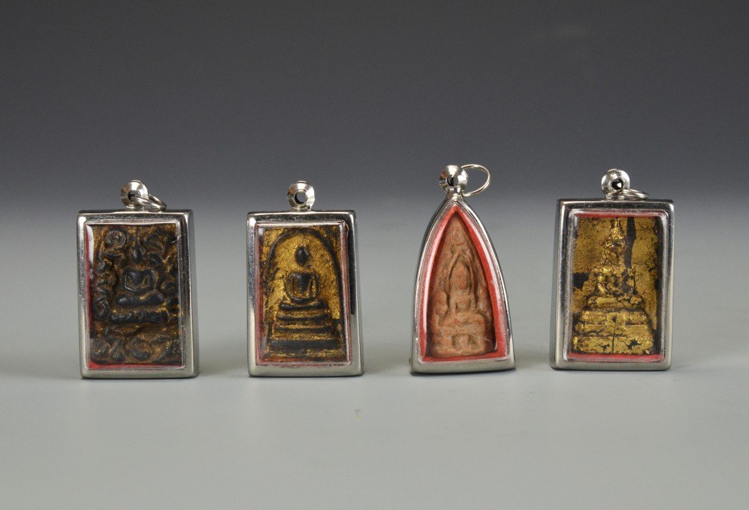 A Collection of Four South Asian Buddhist Amulets: The amulets in the form of gilt Buddhas in plastic cases, one with mother of pearl inlay. Each approx. 2 by 1 1/8 in., 5.1 by 2.9 cm.