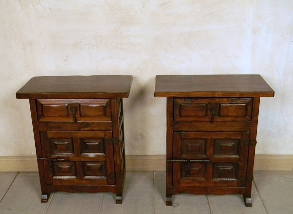 Vintage Spanish Nightstands: A pair of vintage Spanish style night stands made of solid wood with a medium finish and adorned with wrought iron ornaments. Each night stand has one small top drawer and one door. Circa: 1960. Style