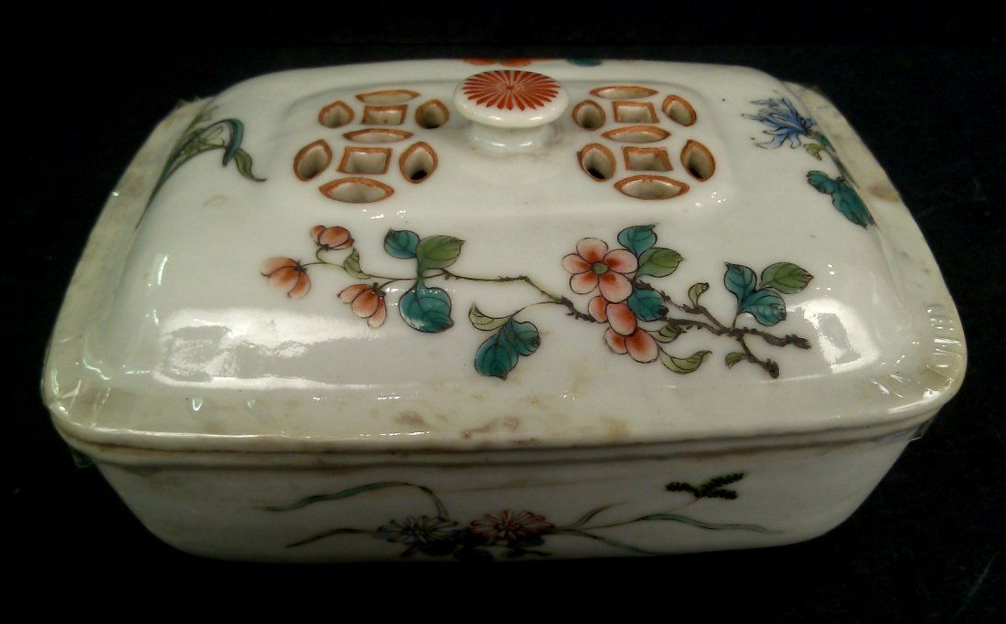 A PORCELAIN FAMILLE ROSE SOAP BOX: Old famille rose Porcelain glazed soap dish with cover; with hollowed and cut out geometric pattern and a chrysanthemum finial, enameled with hand painted peony, wild flowers, bird, and butterflies in