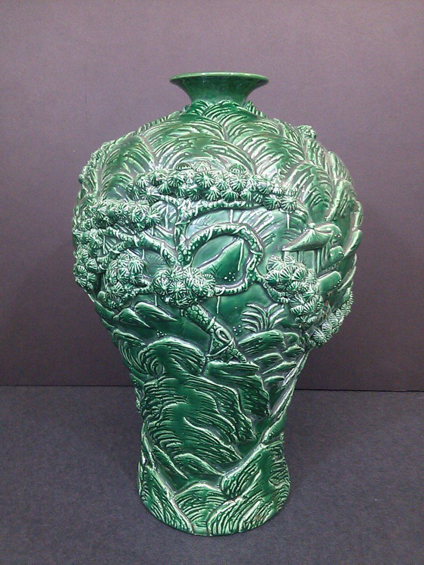 A Qing dynasty green glazed carved porcelain vase