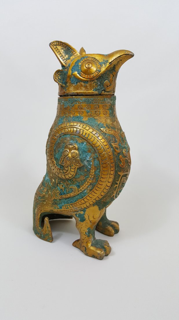 A Shang Style Gilt Bronze Owl Vessel Zun: A gilt bronze standing owl wine vessel, ritual zun sculpture with removable head, Shang style. 11"Hx 8"Wx 4"D