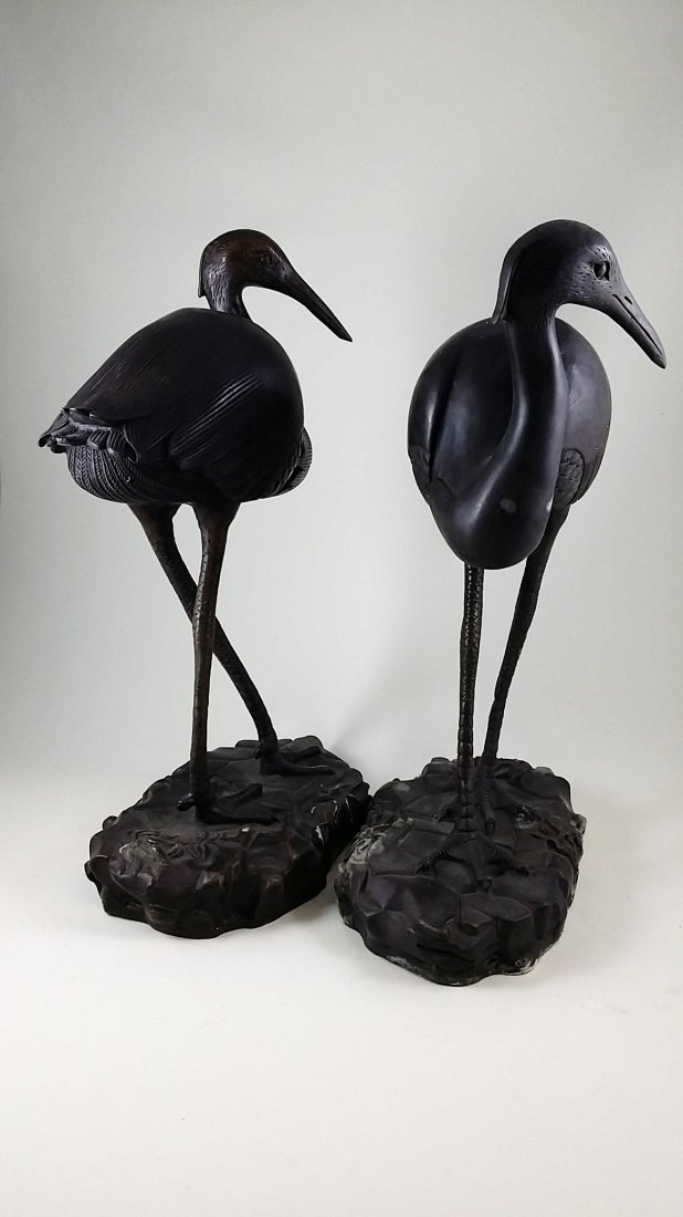 A Pair of Old Chinese Bronze Cranes: A pair of old crane statutes standing over river rocks casted with bronze from China. Measures 7"Lx 12.1/4"H each