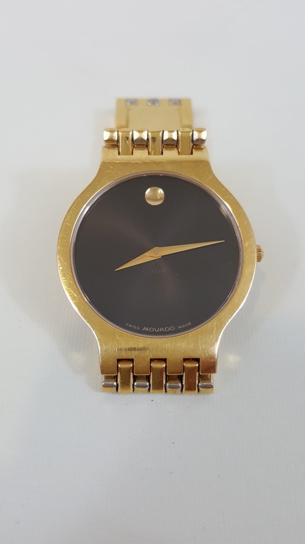 A Movado Esperanza Gold-Tone All Steel Quartz Men's: A Movado Esperanza Gold-Tone Stainless Steel Men's Watch with vertical-link bracelet, sapphire crystal, black museum dial, Swiss quartz movement, water-resistant. 8.5" long