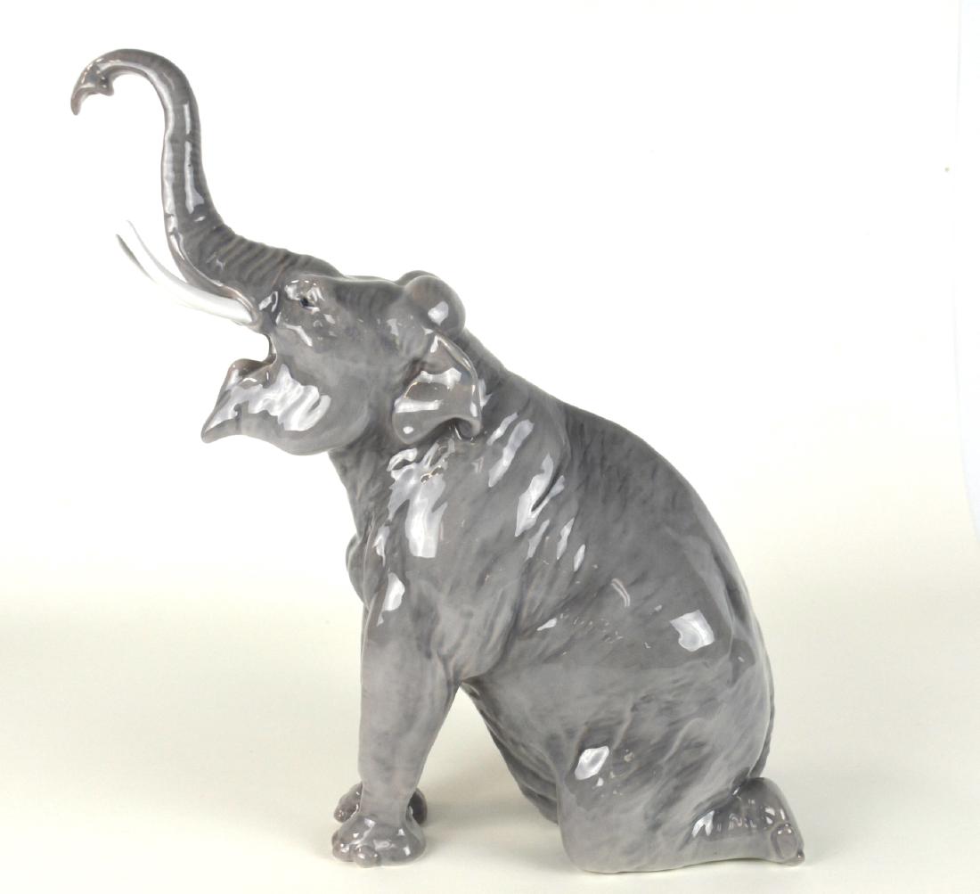 Denmark Bing & Grondahl Porcelain Elephant: Porcelain figurine of an elephant on its knees, made by Royal Copenhagen and Bing & Grondahl. . Mark on the bottom. 11 1/4" x 6 1/4"