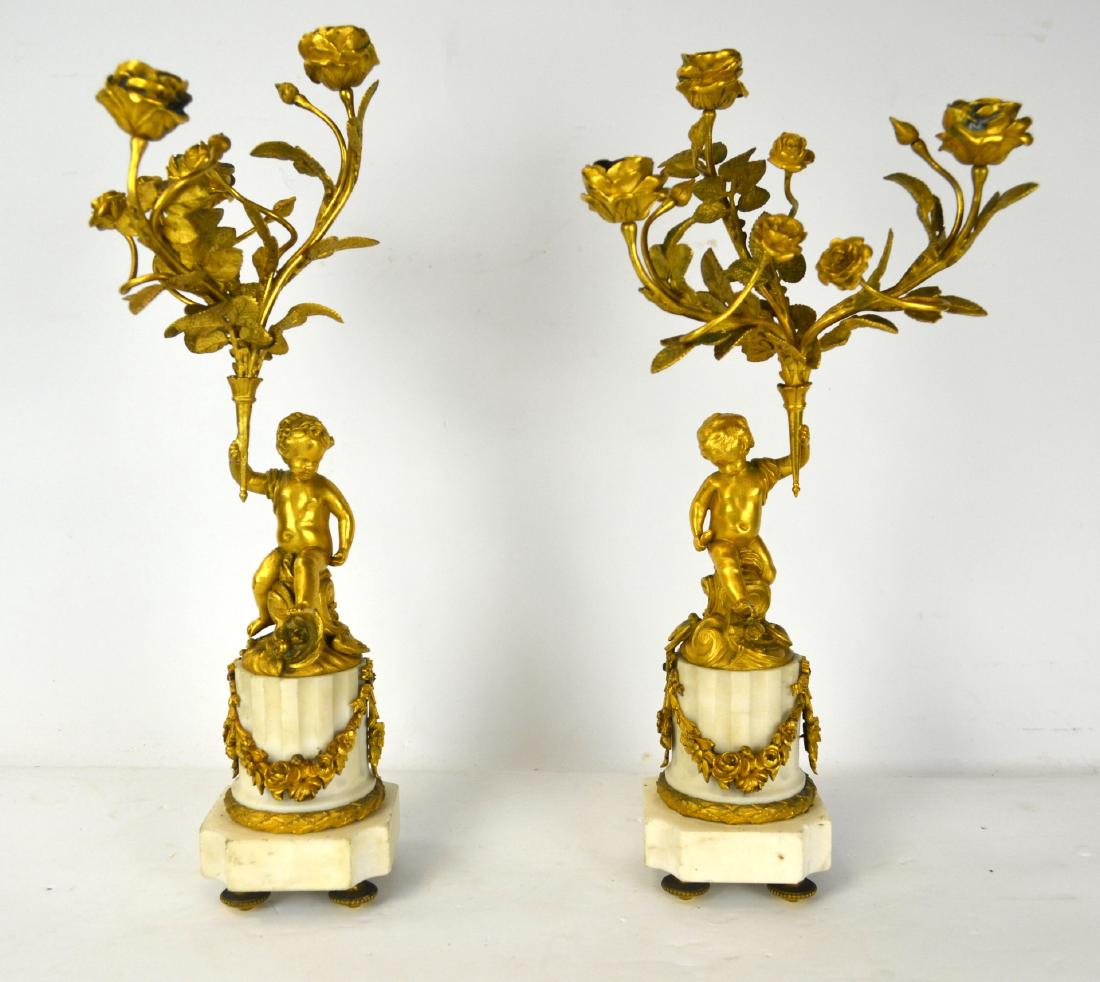 Pair of Fine Bore Bronze Candelabras: Pair of gilt bronze candelabras of status mounted on marble base. Bronze sculpture of a sitting boy holding rose branches. Each with three arms of candle holders. 16 3/4" x 8" , base 3 1/2" x 3 1/2"