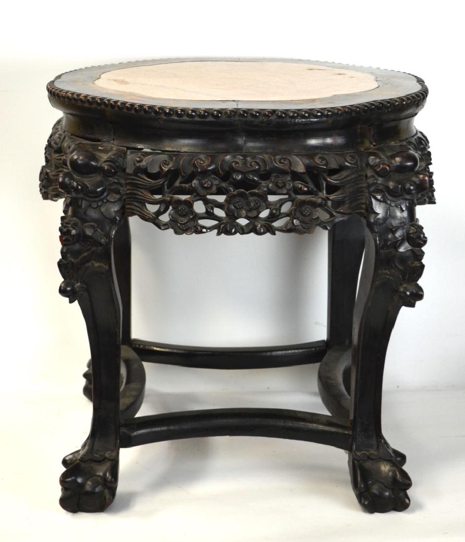 Chinese Wood Stool: A Chinese wood stool with stone inlay, a riveted shape at top and pierced floral carving around sides. Each leg with a lion head at top and claw feet. 11 1/2" H x 21" W