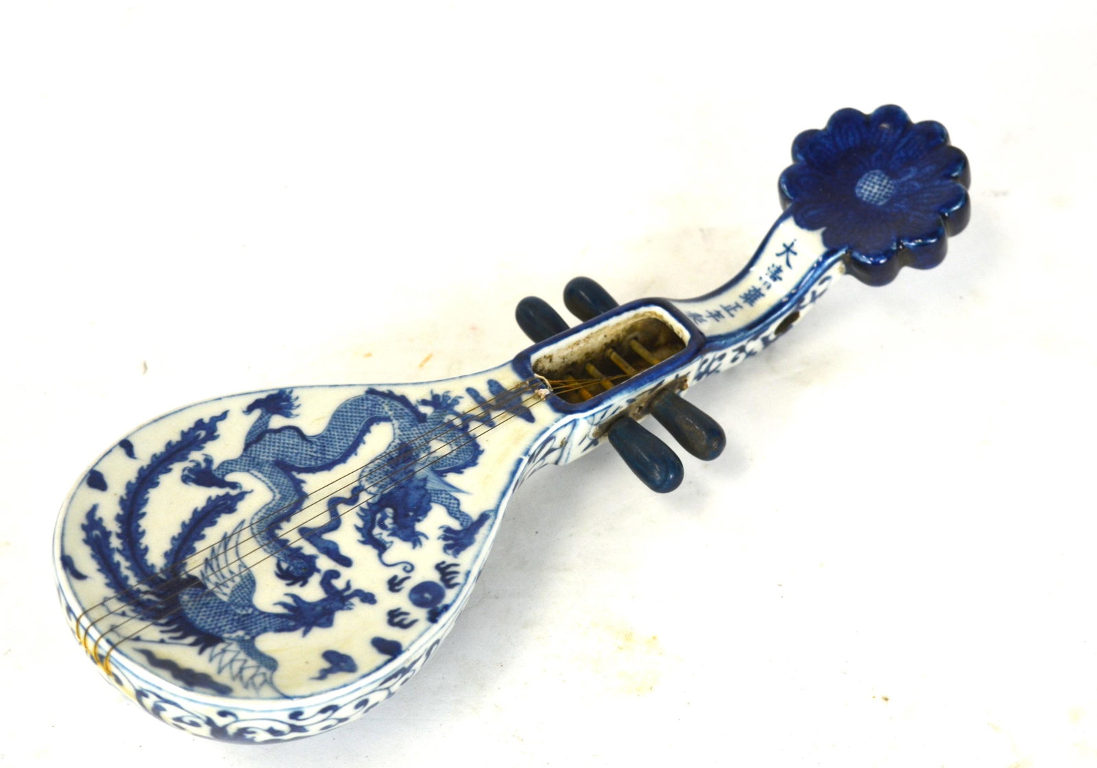 Chinese Blue &White Musician Instrument: Chinese blue and white musical string instrument decorated with dragon and phoenix on the front, scrolling floral design on the back, six-character on the top, missing a turns. 12" x 4 1/4"