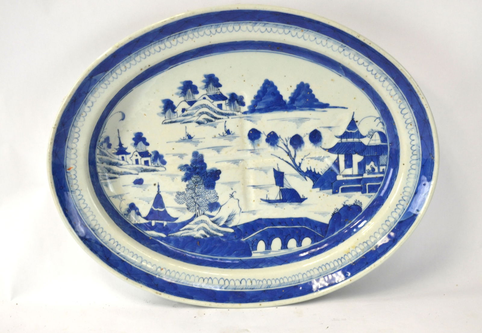 Chinese Blue & White Export Charger: Chinese antique blue and white export oval shape charger painted with landscaping scene. with two legs and one side is deeper. 16 5/8"W x 9 1/4"D x 2 1/2"H