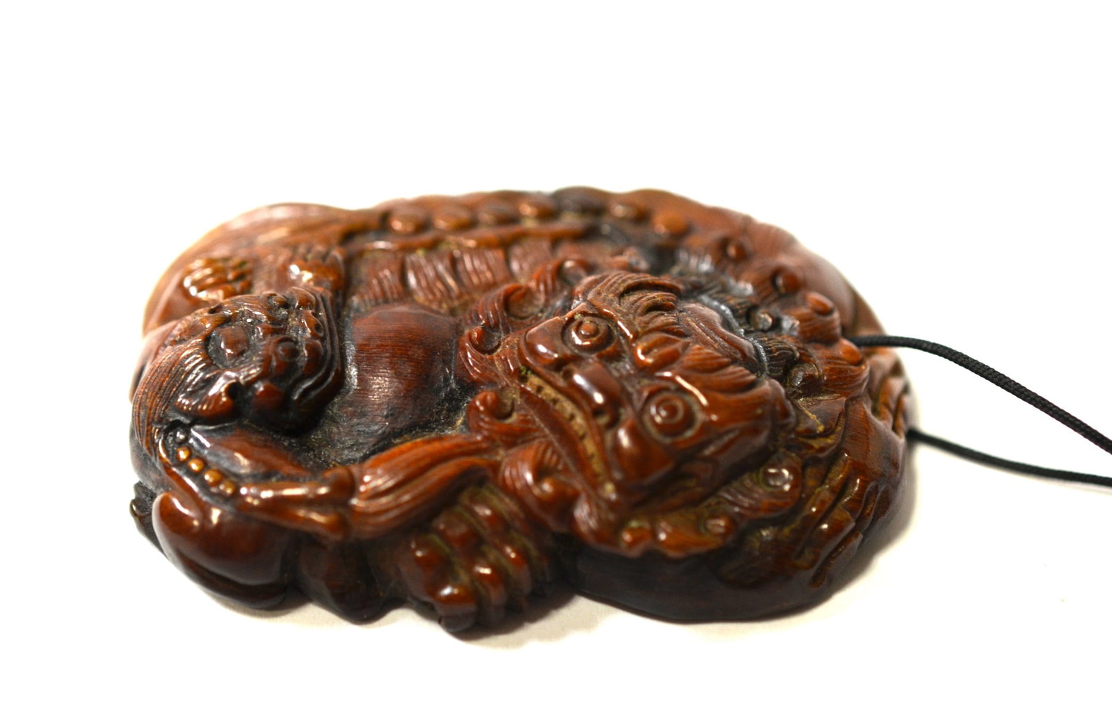 Chinese Carved Horn Pendant: Chinese horn pendant carved with large lion holding a baby lion. 2 1/2" H x 1 3/4" W x 5/8" D