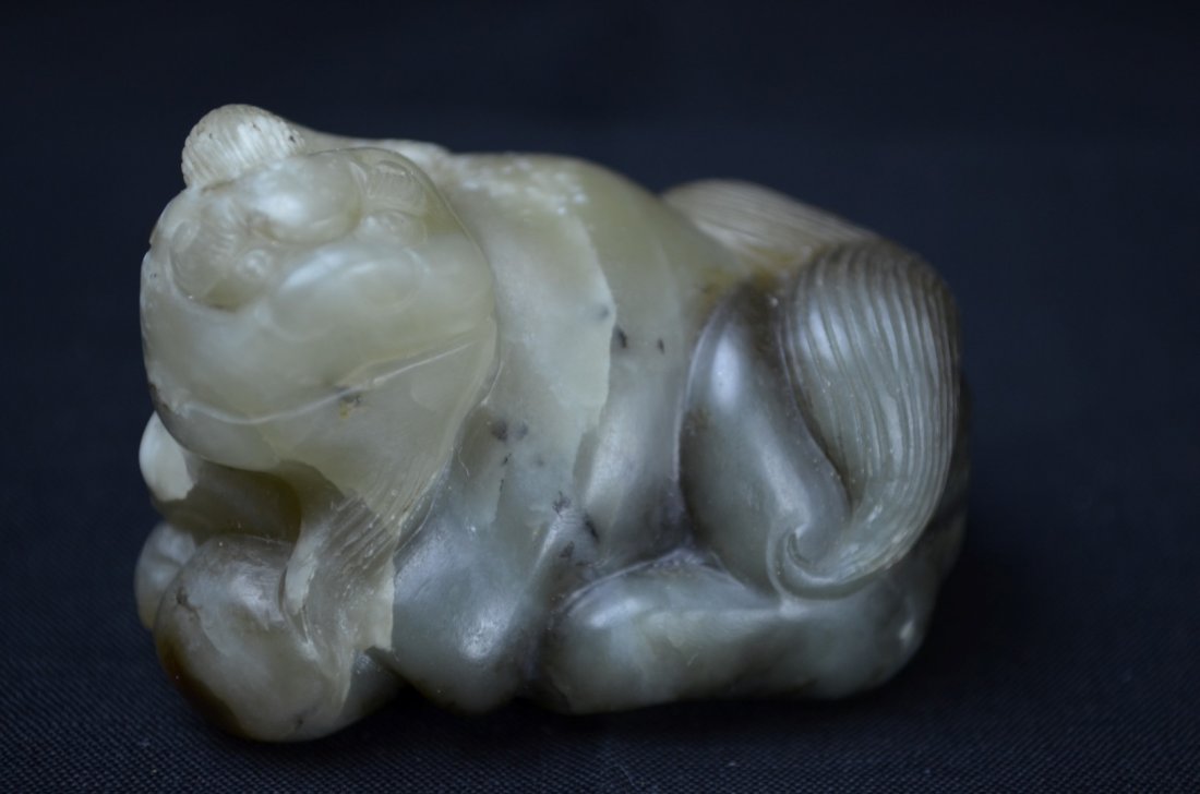 A Small Chinese He Tian Greenish Jade Figure Of Lion: Song Dynasty This small lion is carved out of He Tian Jade. He is lighter green in color and laying down with his tail curled inward. 1 5/8' H 2 1/4' W