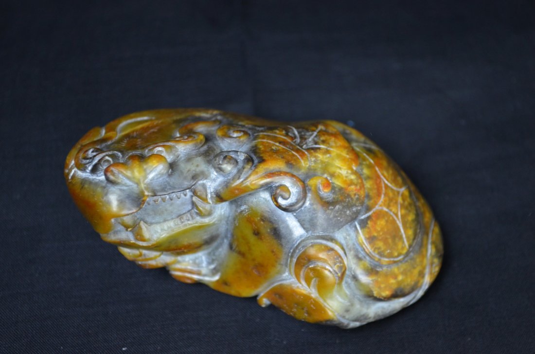 A Large Chinese He Tian Jade Figure Of Lion: Song Dynasty .This lion is carved out of the very rare green He Tian Jade. The lion is laying down with and on his back is the ancient symbol for money. 2 1/8' H 4' W