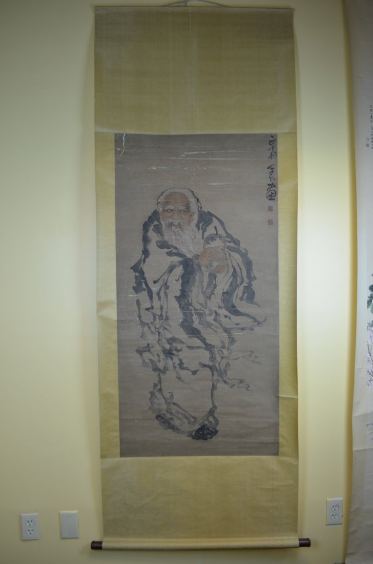 A Chinese Scroll Painting By Bing Zhen: This scroll painting depictsa smiling man in the back round. Done in mostly black ink he is wearing a long flowing robe and is holding a vessel in both hands. 50 1/8' H 25 1/8' W